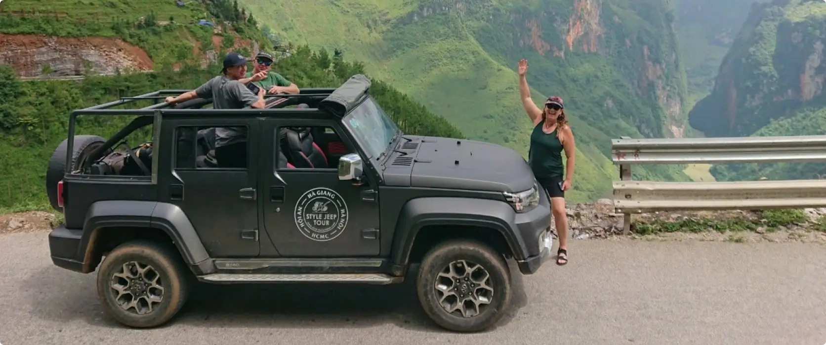 Happy passengers in an open top Jeep in Ha Giang with mountains in the background