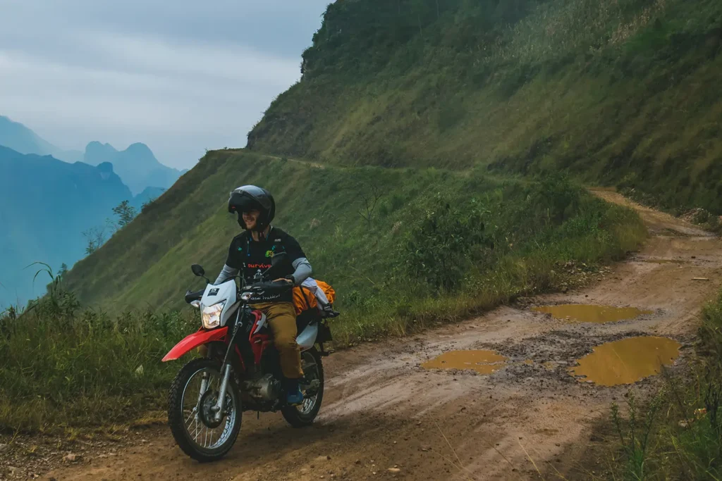 Ha Giang Loop: Why Bike Quality Matters (Your Safety Guide) 2 honda xr driving a dirt track in ha giang with mountain views.